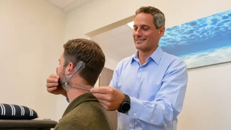 Dr. Penner measuring a patient's neck range of motion with a goniometer